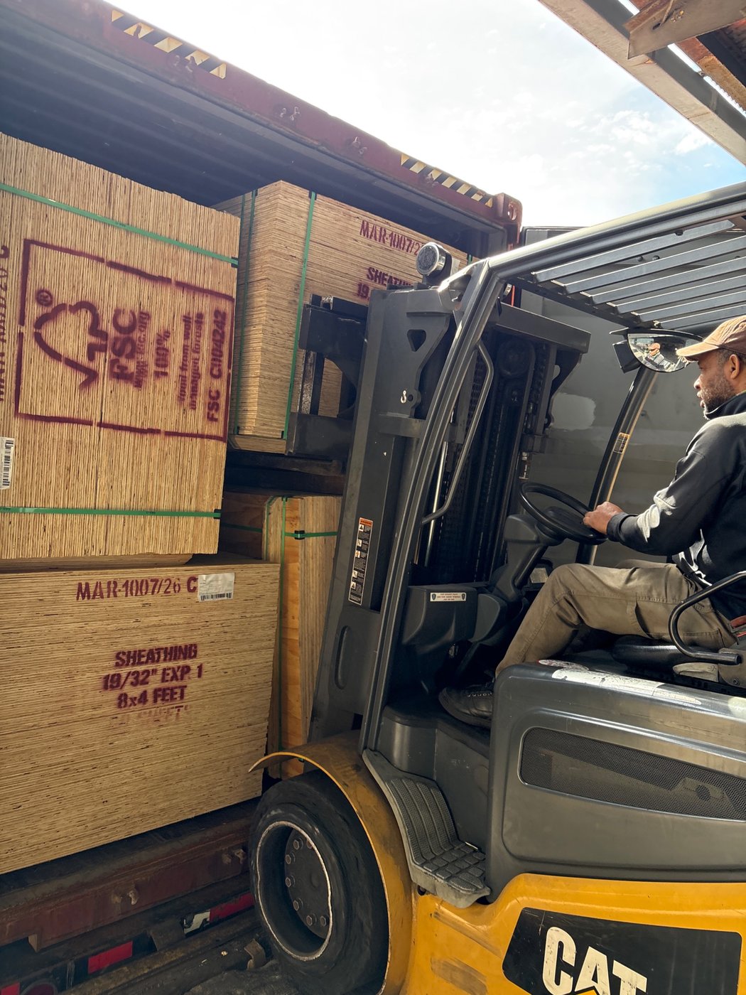 A D&M forklift driver stripping plywood units from an ocean container