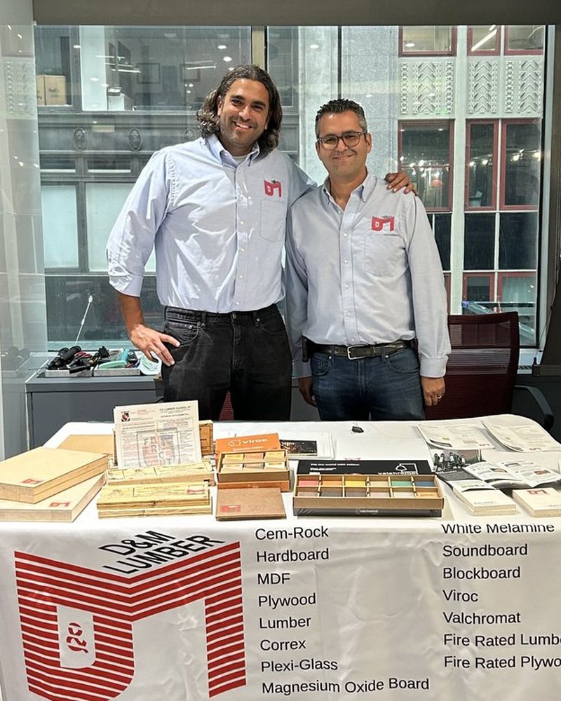 Two of the four family members who run D&M, at a D&M product table with panel samples